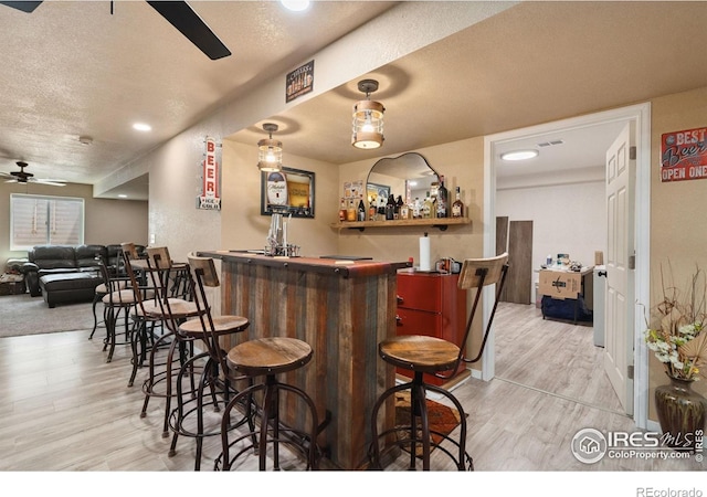 4521 Mesa Verde Dr, Greeley, CO 80634 - indoor bar featuring ceiling fan, wood finished floors, a textured ceiling, and recessed lighting
