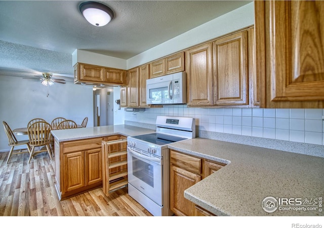 13600 Elmore Rd, Longmont, CO 80504 - kitchen with white appliances, light countertops, ceiling fan, a peninsula, and a textured ceiling