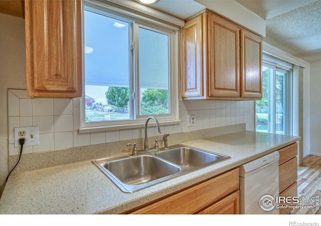 13600 Elmore Rd, Longmont, CO 80504 - kitchen with dishwasher, plenty of natural light, decorative backsplash, light countertops, and a textured ceiling
