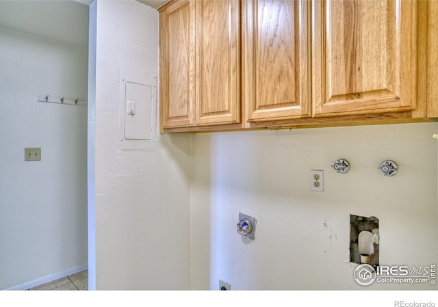 13600 Elmore Rd, Longmont, CO 80504 - laundry area with cabinet space, hookup for an electric dryer, light tile patterned flooring, hookup for a gas dryer, and washer hookup