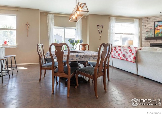 1773 Nightfall Dr, Windsor, CO 80550 - dining area featuring plenty of natural light, dark wood-style floors, and a fireplace