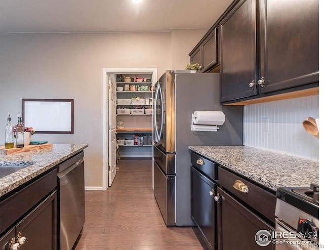 1773 Nightfall Dr, Windsor, CO 80550 - kitchen with stainless steel appliances, dark wood finished floors, light stone counters, and dark brown cabinetry