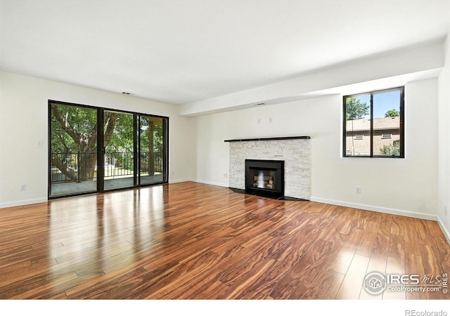 600 Manhattan Dr Unit B7, Boulder, CO 80303 - unfurnished living room with wood finished floors, plenty of natural light, and a fireplace