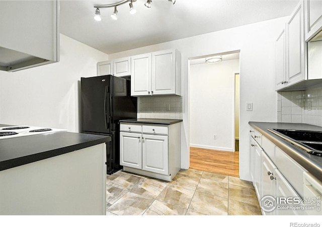 600 Manhattan Dr Unit B7, Boulder, CO 80303 - kitchen featuring freestanding refrigerator, dark countertops, white cabinets, and backsplash