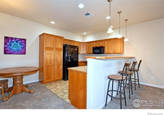 3641 29th St Unit 6, Greeley, CO 80634 - kitchen with black appliances, a breakfast bar area, a peninsula, recessed lighting, and decorative light fixtures