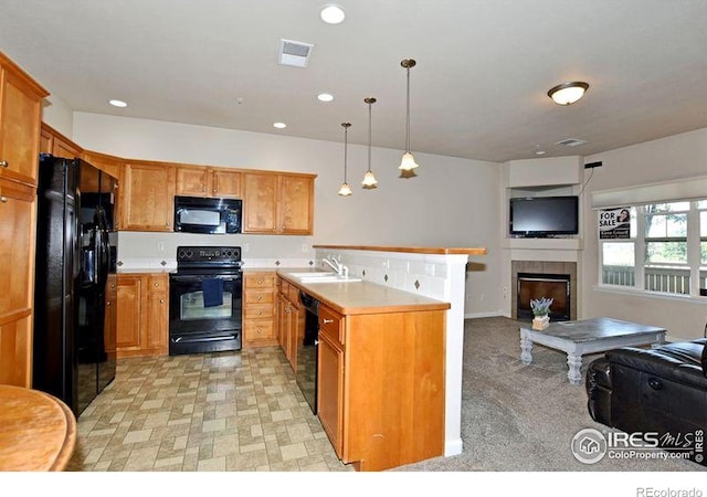 3641 29th St Unit 6, Greeley, CO 80634 - kitchen with black appliances, a peninsula, open floor plan, light countertops, and a tile fireplace