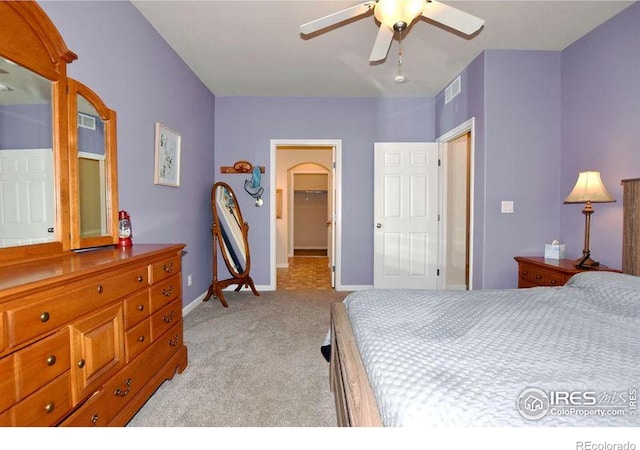 3641 29th St Unit 6, Greeley, CO 80634 - bedroom with light colored carpet, a walk in closet, ceiling fan, and arched walkways