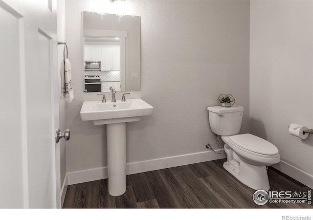 2402 49th Avenue Ct Unit 17, Greeley, CO 80634 - bathroom featuring wood finished floors and tasteful backsplash