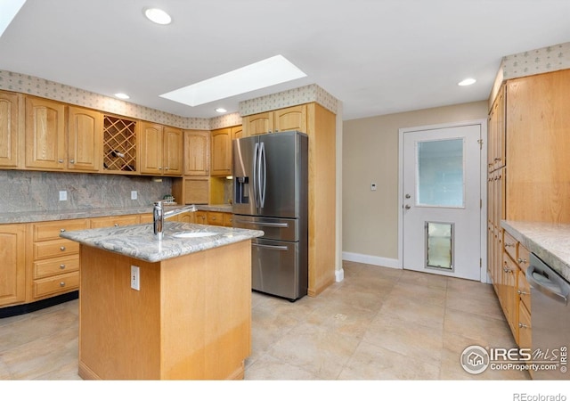 10947 Lynne Ave, Lafayette, CO 80026 - kitchen with stainless steel appliances, a skylight, light stone counters, tasteful backsplash, and recessed lighting