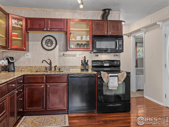 2301 US Highway 34, Drake, CO 80515 - kitchen with black appliances, dark brown cabinets, wood finished floors, light stone countertops, and glass insert cabinets