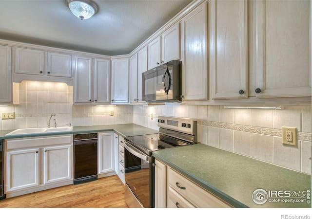 1925 28th Ave Unit 30, Greeley, CO 80634 - kitchen featuring electric stove, black microwave, backsplash, light wood finished floors, and dark countertops