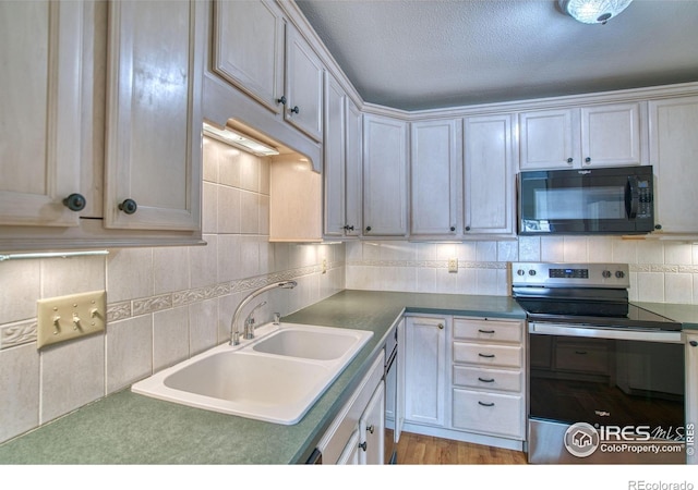 1925 28th Ave Unit 30, Greeley, CO 80634 - kitchen with black microwave, stainless steel range with electric stovetop, tasteful backsplash, light wood finished floors, and a textured ceiling