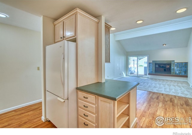 1925 28th Ave Unit 30, Greeley, CO 80634 - kitchen with freestanding refrigerator, light brown cabinetry, light wood-type flooring, lofted ceiling, and dark countertops