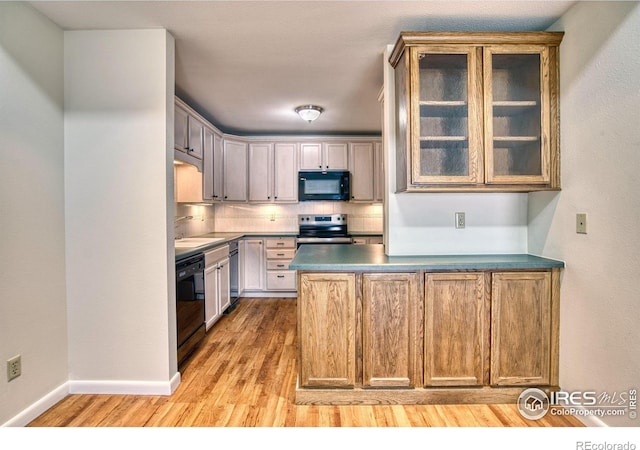 1925 28th Ave Unit 30, Greeley, CO 80634 - kitchen with black appliances, light wood-style floors, a peninsula, tasteful backsplash, and glass insert cabinets