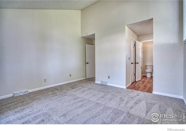 1925 28th Ave Unit 30, Greeley, CO 80634 - carpeted empty room with baseboards and high vaulted ceiling