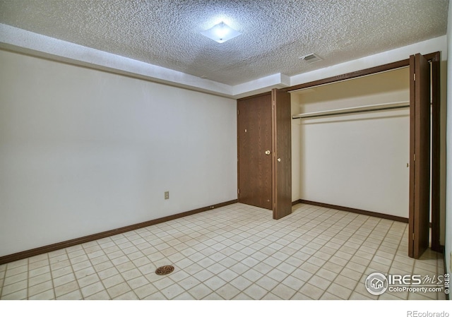 1925 28th Ave Unit 30, Greeley, CO 80634 - unfurnished bedroom with a textured ceiling, a closet, and light tile patterned floors