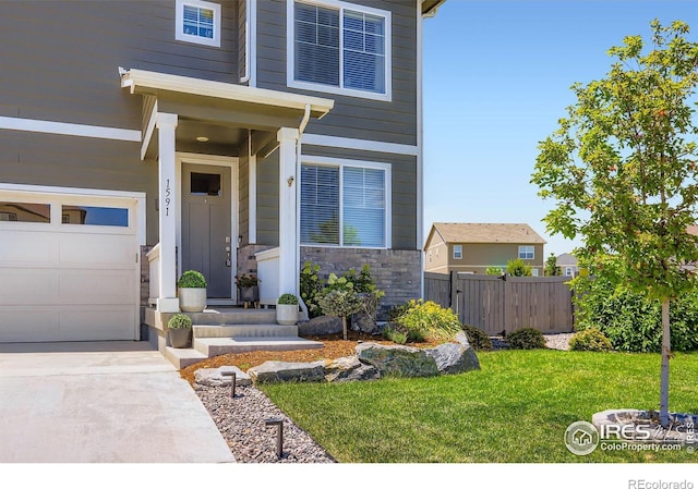 1591 Sun River Rd, Berthoud, CO 80513 - view of exterior entry with a garage, stone siding, and driveway