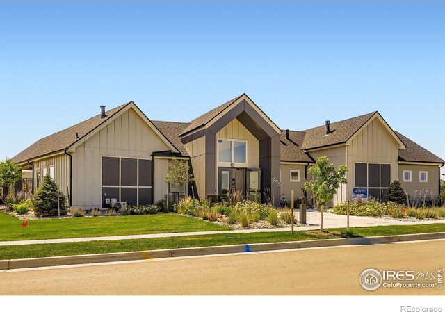 1591 Sun River Rd, Berthoud, CO 80513 - view of front of property with board and batten siding, a front lawn, and roof with shingles