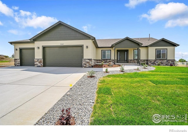 3643 Crested Owl Ct, Dacono, CO 80514 - view of front of home featuring a garage, stone siding, driveway, and a front lawn