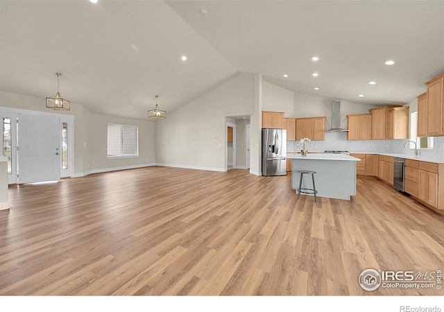 3643 Crested Owl Ct, Dacono, CO 80514 - kitchen featuring stainless steel appliances, wall chimney exhaust hood, open floor plan, light countertops, and a center island with sink