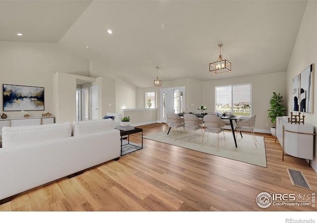 3643 Crested Owl Ct, Dacono, CO 80514 - living room with vaulted ceiling, wood finished floors, a chandelier, and recessed lighting