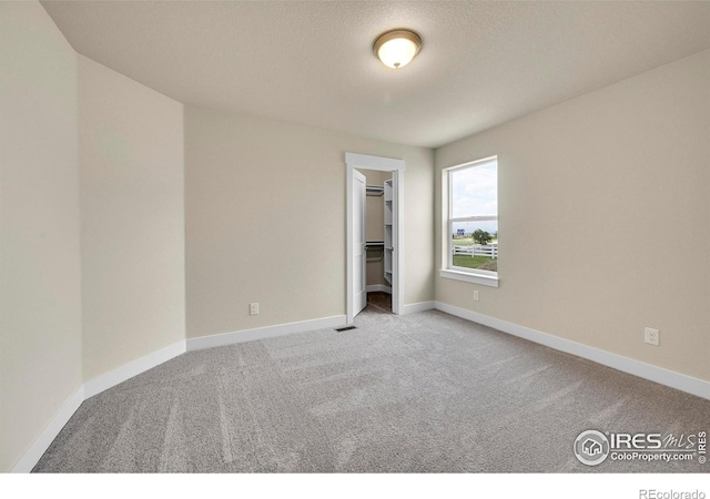 3643 Crested Owl Ct, Dacono, CO 80514 - unfurnished bedroom featuring carpet flooring and a walk in closet