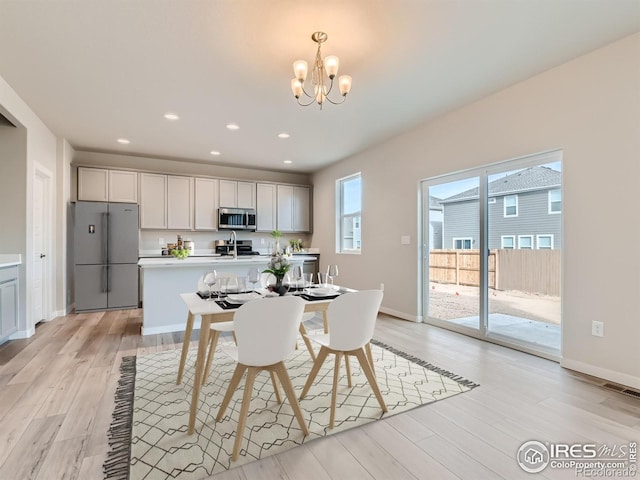 13 Chipeta Way, Lochbuie, CO 80603 - dining room featuring a chandelier, light wood-style flooring, and recessed lighting