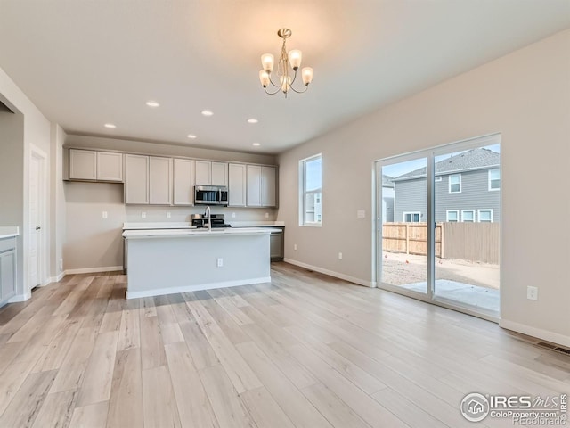 13 Chipeta Way, Lochbuie, CO 80603 - kitchen featuring stainless steel microwave, a chandelier, light wood-style floors, light countertops, and recessed lighting