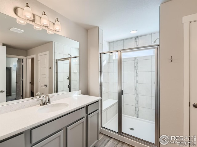 13 Chipeta Way, Lochbuie, CO 80603 - full bathroom featuring a stall shower, vanity, and wood finished floors