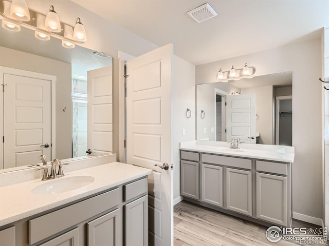 13 Chipeta Way, Lochbuie, CO 80603 - bathroom featuring two vanities, wood finished floors, and a shower