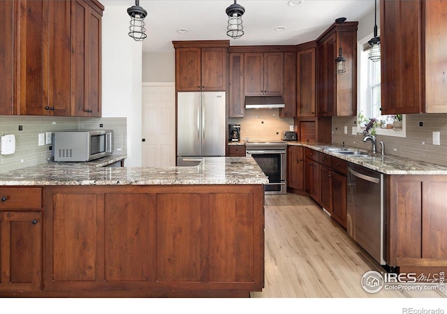 691 Tamarisk Ct, Louisville, CO 80027 - kitchen featuring stainless steel appliances, under cabinet range hood, tasteful backsplash, and light stone counters