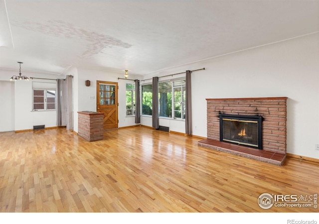 2940 9th St, Boulder, CO 80304 - unfurnished living room with wood finished floors, a chandelier, and a glass covered fireplace