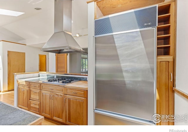 2940 9th St, Boulder, CO 80304 - kitchen with appliances with stainless steel finishes, island exhaust hood, a skylight, light wood finished floors, and vaulted ceiling