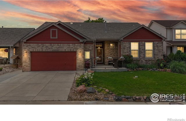 555 S 17th Ave, Brighton, CO 80601 - craftsman-style house with concrete driveway, a lawn, brick siding, and a garage