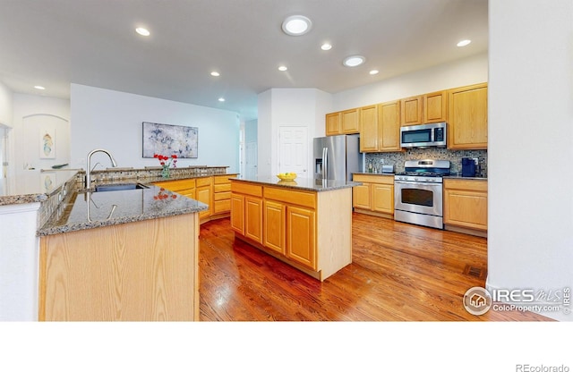 555 S 17th Ave, Brighton, CO 80601 - kitchen featuring stainless steel appliances, a spacious island, wood finished floors, recessed lighting, and decorative backsplash