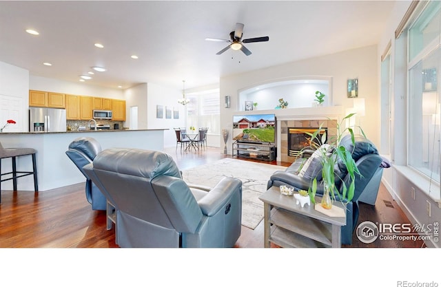 555 S 17th Ave, Brighton, CO 80601 - living room with wood finished floors, recessed lighting, a tile fireplace, a ceiling fan, and a chandelier
