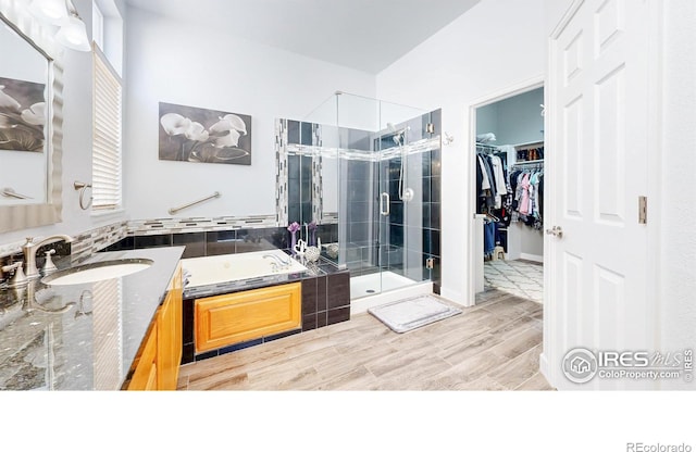 555 S 17th Ave, Brighton, CO 80601 - full bathroom with a stall shower, a garden tub, vanity, wood finished floors, and a spacious closet