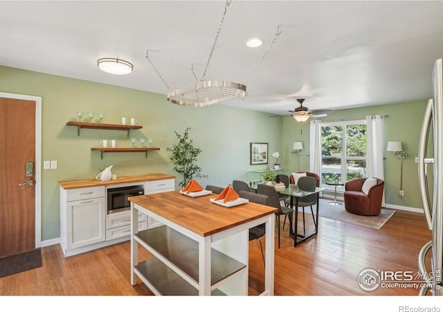 1430 Kennedy Ave, Louisville, CO 80027 - kitchen featuring black microwave, wood counters, white cabinets, freestanding refrigerator, and a ceiling fan