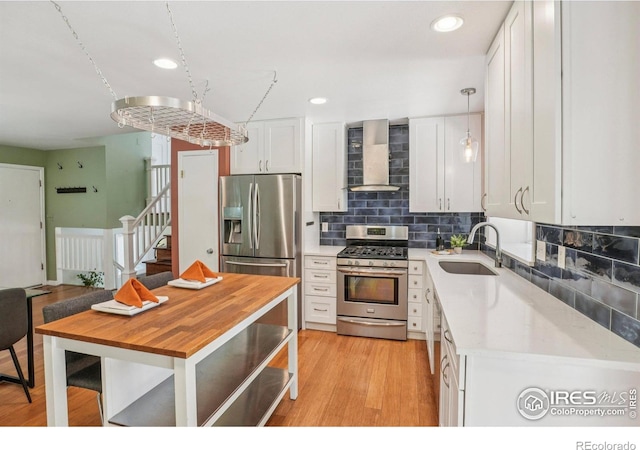 1430 Kennedy Ave, Louisville, CO 80027 - kitchen with wall chimney exhaust hood, appliances with stainless steel finishes, white cabinets, backsplash, and recessed lighting