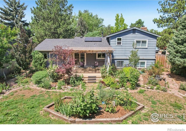 1430 Kennedy Ave, Louisville, CO 80027 - split level home featuring a garden, solar panels, and a chimney