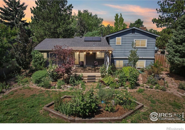1430 Kennedy Ave, Louisville, CO 80027 - split level home with a garden, solar panels, a chimney, and a porch