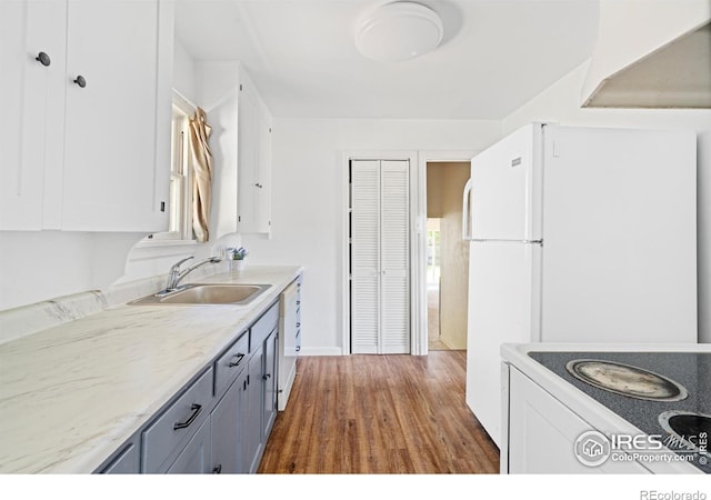 612 20th St, Greeley, CO 80631 - kitchen with white cabinetry, white appliances, wood finished floors, light countertops, and gray cabinetry