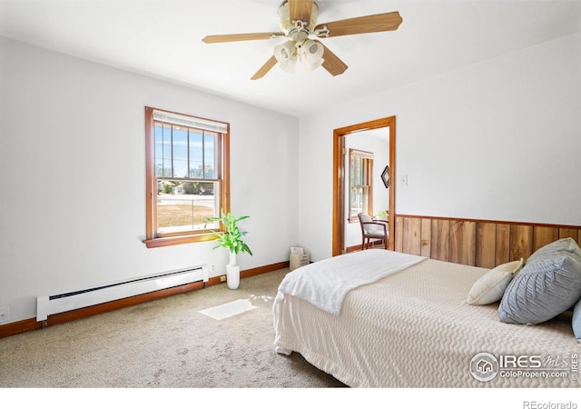 612 20th St, Greeley, CO 80631 - bedroom featuring a baseboard heating unit, carpet floors, a ceiling fan, and wooden walls