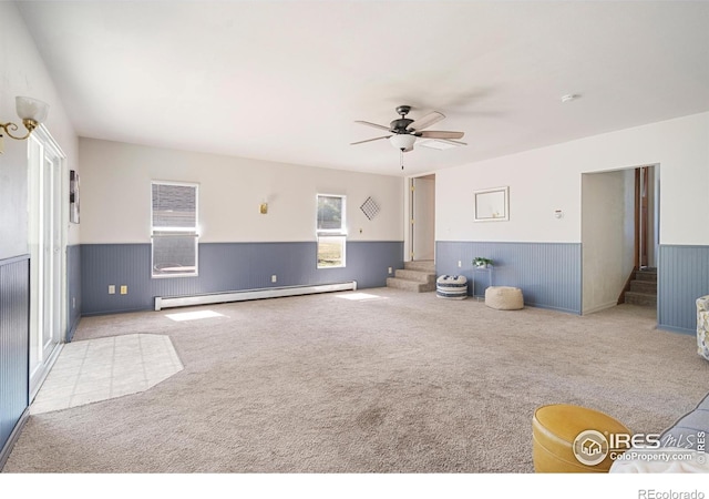 612 20th St, Greeley, CO 80631 - unfurnished living room with baseboard heating, a wainscoted wall, stairs, and carpet flooring