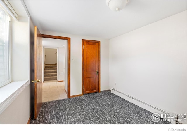 612 20th St, Greeley, CO 80631 - unfurnished room with baseboard heating, dark carpet, and stairs