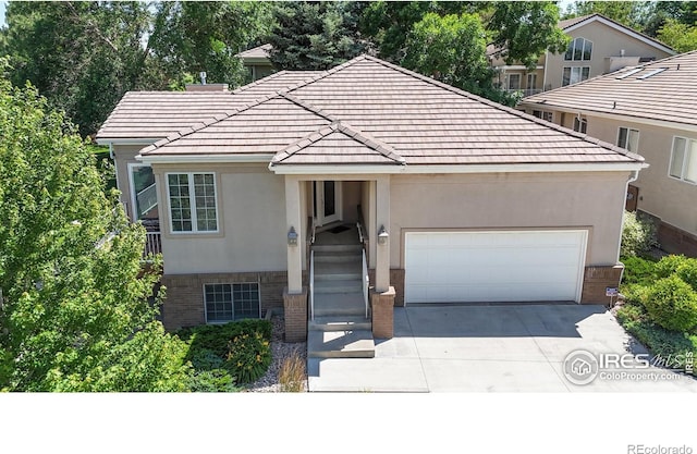 7294 Tamarisk Dr, Fort Collins, CO 80528 - traditional-style house featuring brick siding, concrete driveway, an attached garage, stucco siding, and a tile roof
