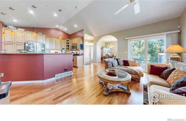 7294 Tamarisk Dr, Fort Collins, CO 80528 - living area featuring arched walkways, vaulted ceiling, light wood finished floors, a ceiling fan, and a chandelier