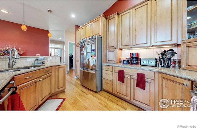 7294 Tamarisk Dr, Fort Collins, CO 80528 - kitchen with stainless steel fridge, decorative backsplash, light wood finished floors, decorative light fixtures, and recessed lighting