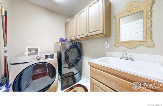 7294 Tamarisk Dr, Fort Collins, CO 80528 - laundry room with cabinet space and washer and clothes dryer