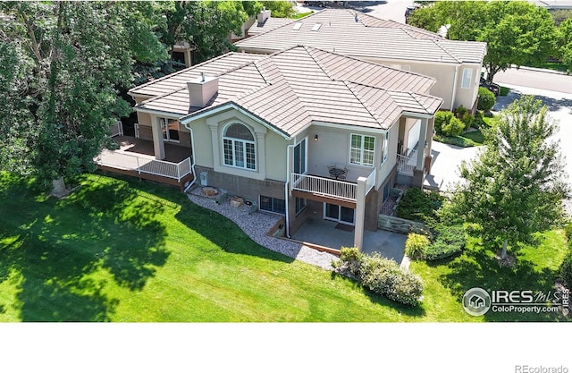 7294 Tamarisk Dr, Fort Collins, CO 80528 - rear view of house with a yard, stucco siding, a tiled roof, a deck, and a patio